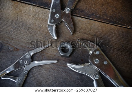 close up locking pliers on wooden background, Hand tools in work shop.