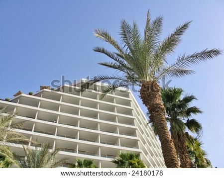 Modern hotel building with palm trees