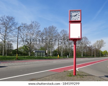 Clock with empty advertisting board on the road