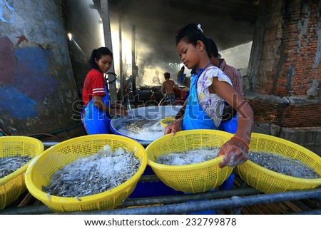 unidentified woman work in the boiling fish factory in Thailand on 17 August 2014