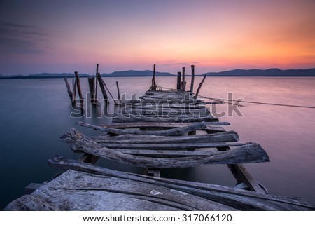 old wooden bridge at the sea with beautiful twilight sky
