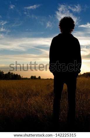 Man standing in field looking into distance
