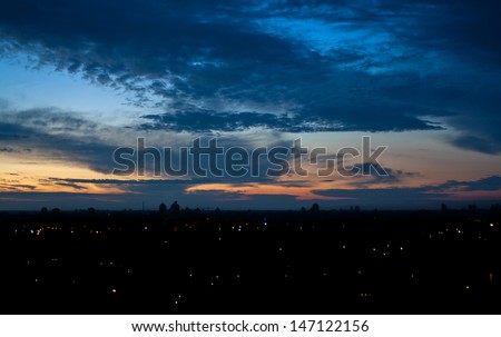 Romantic evening or night cloudscape in city, city lights, overcast sky