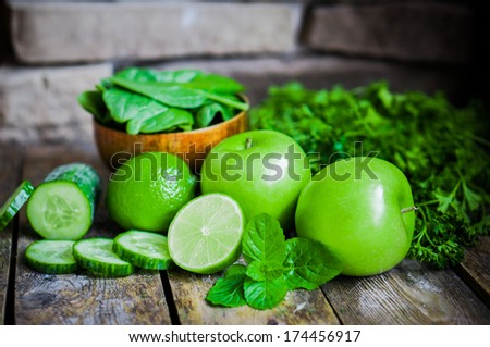 Green fruits and vegetables on wooden background