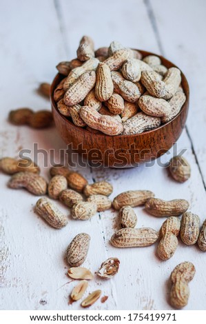 Roasted peanuts on white wooden background