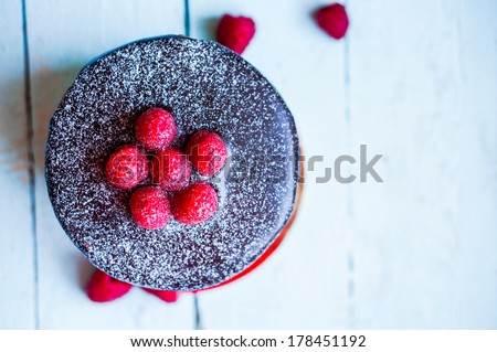 Chocolate cake with raspberries on wooden background