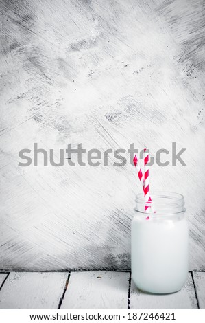 Milk jar on wooden rustic background