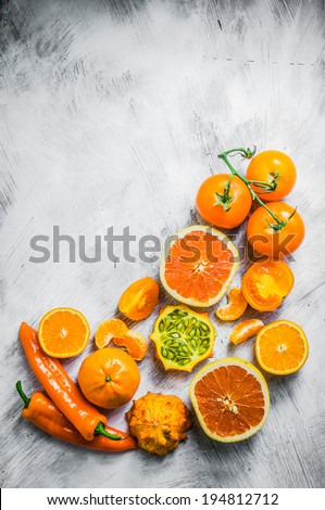 Orange fruits and vegetables on rustic background