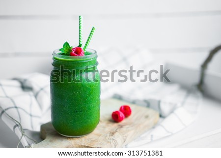 Fresh green smoothie on white wooden background