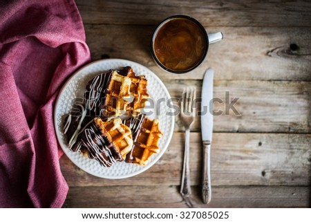 Belgian waffles with chocolate on rustic wooden background
