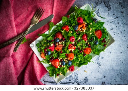 Healthy salad with arugula,spinach,smoked salmon and berries