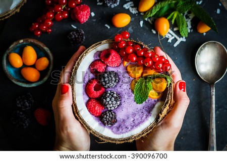 Berry smoothie with berries in coconut on rustic background