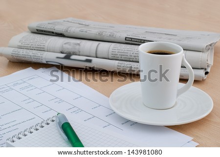 taking a coffee at the office desk with the morning newspaper background