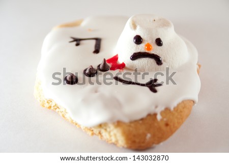 A melted snowman cookie on a white background.