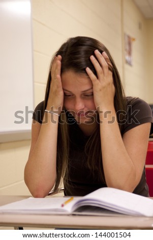 Female Student concentrating on her school work at her desk.