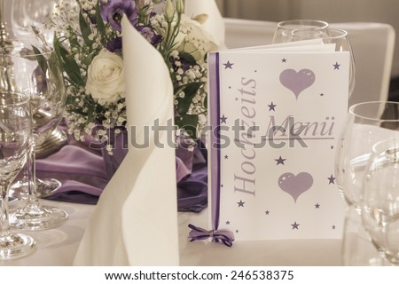 Wedding table with menu card napkins and flowers. High class arrangement for the lucky bride and groom on their big day