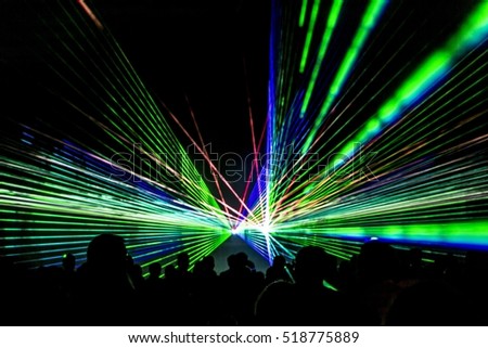 Laser show rays stream. Very colorful show with a crowd silhouette and great laser rays on great afterwork party