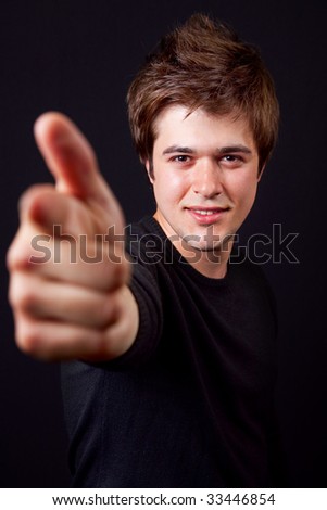 Handsome young man pointing forward with his finger