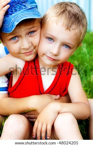 Hug of two cute loving brothers outdoors