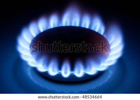 stock photo Methane blue flames at kitchen cooker in the dark