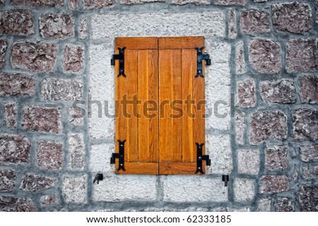 Wooden rustic antique window and textured stone wall