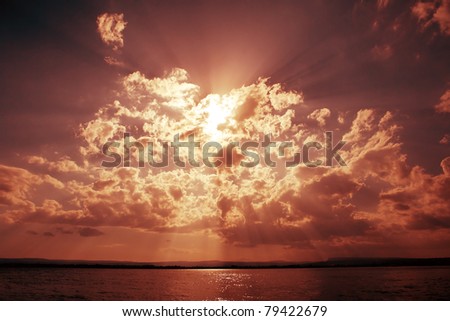 Dramatic sky with clouds and sun beams over ocean