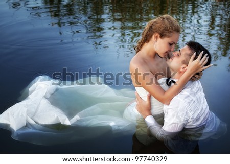Love and passion - kiss of married young couple in water