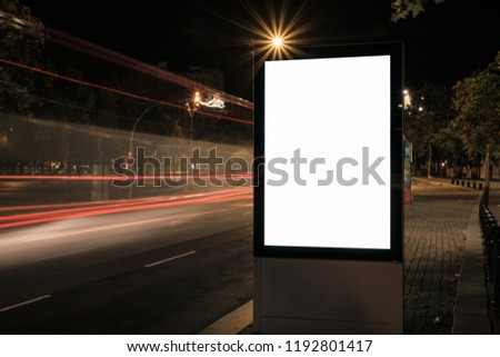 Light box display with white blank space for advertisement. Mock-up design concept with beautiful car light trails at night. Long exposure.
