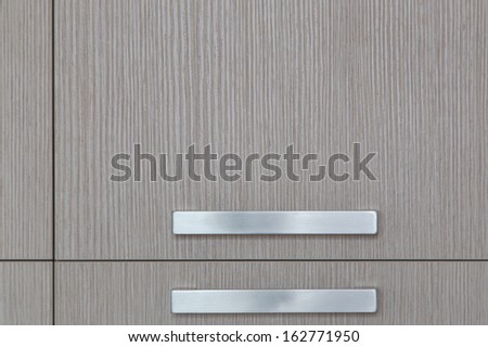 Modern silver handles on a light color furniture piece