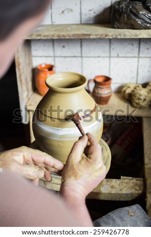 Potter hands making in clay on pottery wheel. Potter makes on the pottery wheel clay pot.