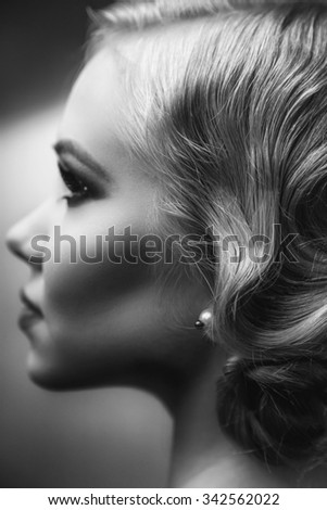 Beautiful retro chic blonde girl in black dress wearing pearls. Beauty Retro Woman Portrait. Glamour Lady. Vintage styled Girl with perfect make up and hairstyle. B&W Photo