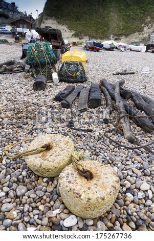 Trawler fishing nets and equipment set out on the stony beach at Beer, Devon, England, United Kingdom