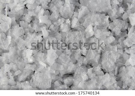 Pile of welsh sea salt flakes on dark slate background. The salt is from Anglesey, Wales, United Kingdom, granted EU protected status in 2014. Close up.