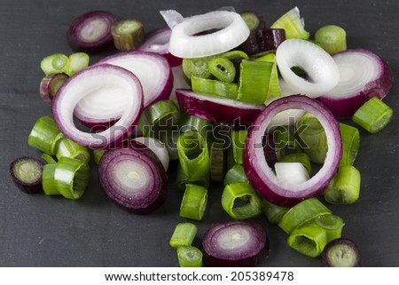 Close up of slices of purple and green scallions, green onion, spring onion, salad onion, table onion, green shallot, onion stick, long onion, baby onion, precious onion, yard onion, gibbon, syboe.