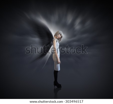 Woman with black wing and white silver hair on dark background