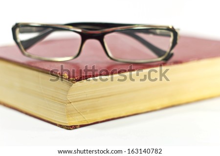 Old glasses on the old diary on white background