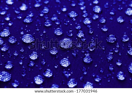 Water droplets on blue fiber waterproof fabric background