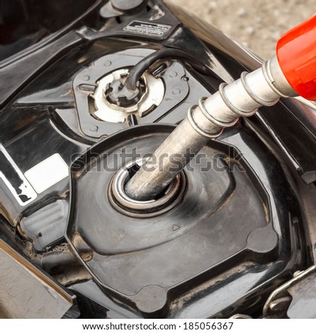 Refueling a motorcycle at a gas station