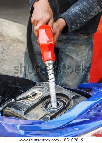 Refueling a motorcycle at a gas station