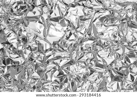 Silver leaf  foil background with shiny crumpled uneven surface for texture background
