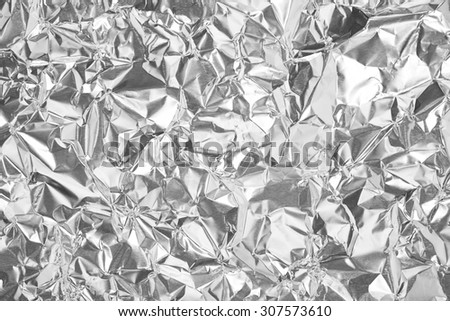 silver leaf foil background with shiny crumpled uneven surface for texture and background