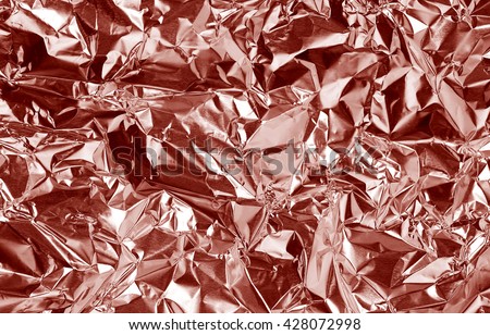 Pink rose gold foil background with shiny crumpled uneven surface for texture and background