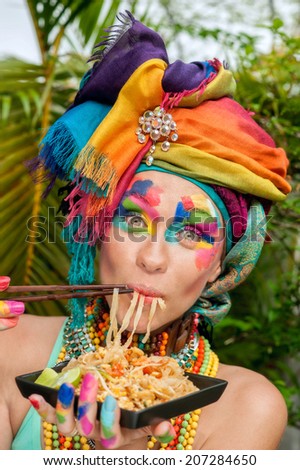 girl with bright makeup eating noodles,	happy,beautiful, lush makeup on beautiful girl,girl-rainbow,laughs