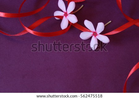 flower and ribbon on purple background with space for message or quote