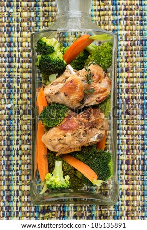 prepared chicken with boiled vegetables in bottle