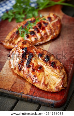prepared on grill chicken fillet on cutting board with parsley