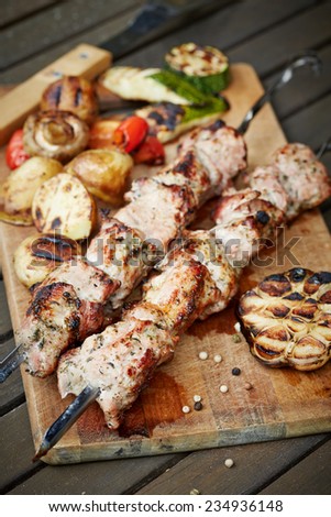prepared on grill pieces of meat on cutting board with vegetables. Shashlik