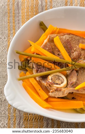 prepared meat with bone and carrot slices. Vertical image.