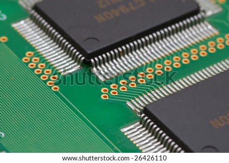 Integrated circuits on the printed circuit board.  Parallel lines on the left and golden contact holes.