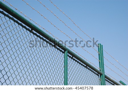 Mesh wired fence with barber wire on the top.